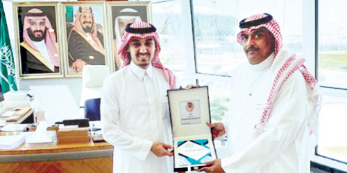  الجوهر أثناء تسليمه نسخة من كتابه للأمير عبدالعزيز الفيصل