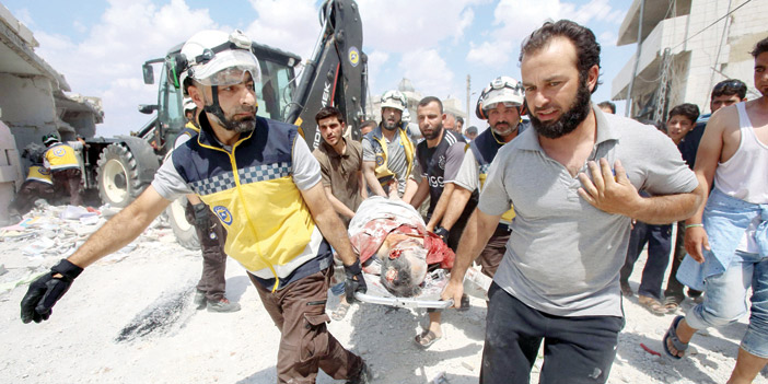  منقذون سوريون يحملون شخصاً أُصيب  جراء غارات النظام