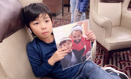  ابن المشجع الياباني يحمل صوره له مع النجم ياسر