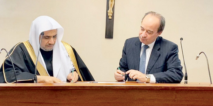  د. العيسى ورئيس الجامعة الكاثوليكية أثناء توقيع الاتفاقية