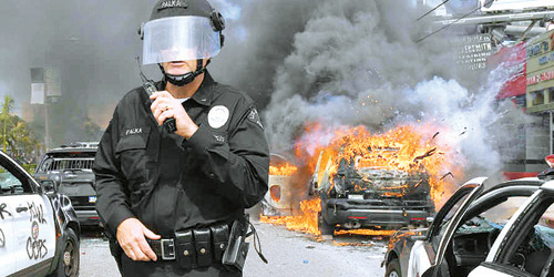   شرطي أمريكي في أحد مواقع الفوضى أثر أعمال الشغب