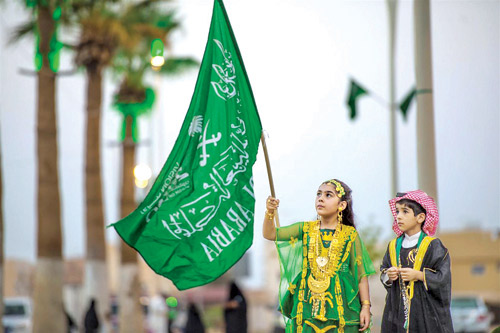 طفلان يلوحان بالعلم السعودي خلال الاحتفالات باليوم الوطني السعودي الـ(90) 
