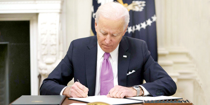  الرئيس الأمريكي بايدن أثناء توقيع عدد من الطلبات التنفيذية لمواجهة كوفيد- 19