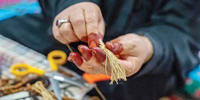 «أم لافي»: أصنع السبح من نواة زيتون الجوف 