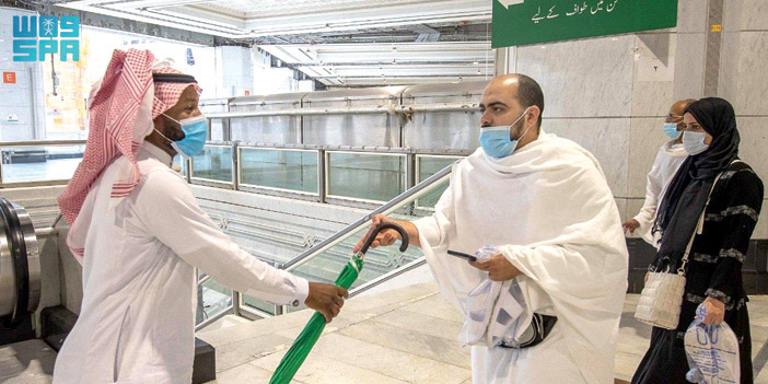  توزيع المظلات على المعتمرين والمصلين