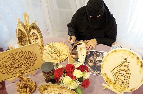 موهبة سعودية تجيد الرسم والخط بـ«فن الحرق على الخشب» 