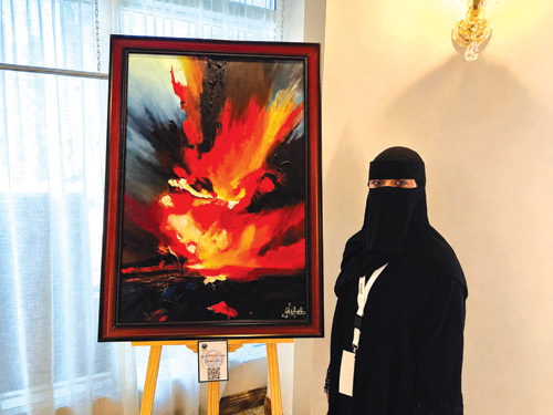 الفنانة التشكيلية سحاب تتوسط أعمالها الفنية